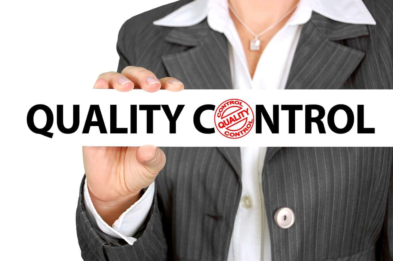 A person holding a sign that says "Quality control".