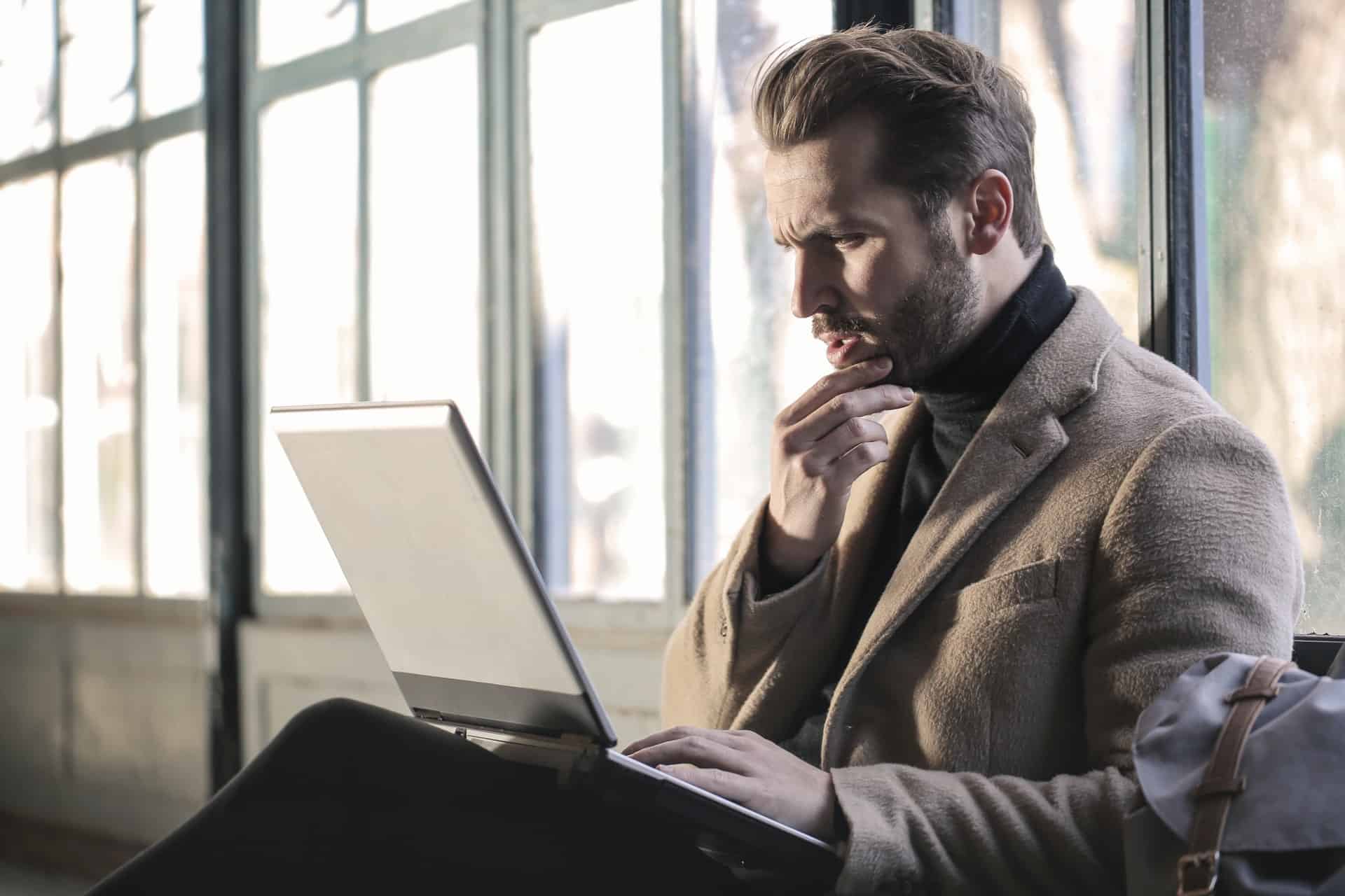 Man looking at laptop in confusion