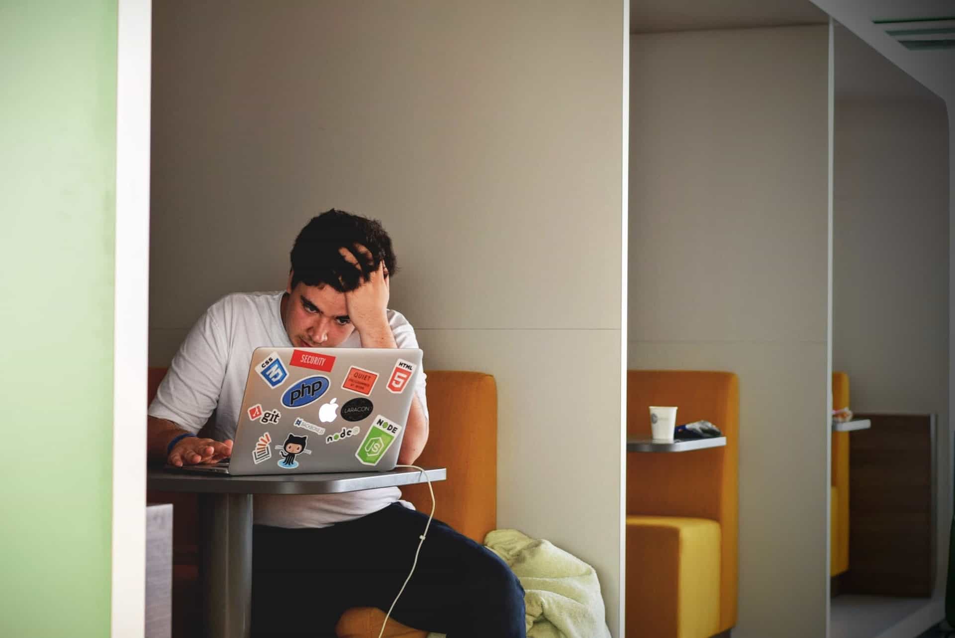 Man stressed in front of laptop