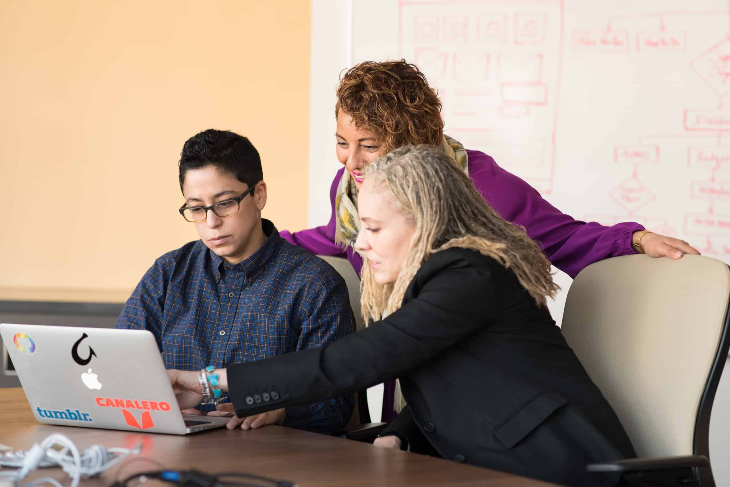 3 people looking at laptop