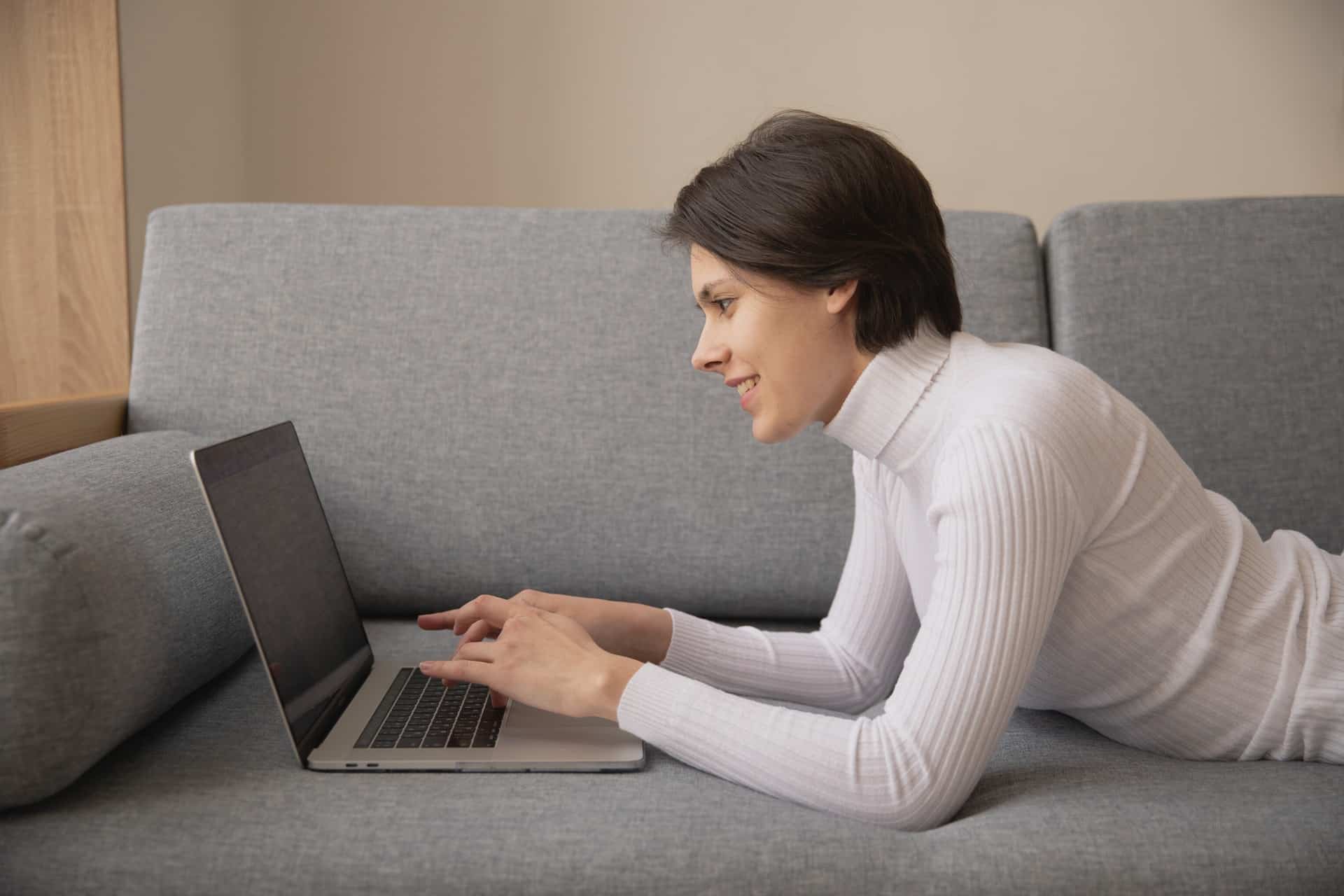 Woman on sofa using laptop