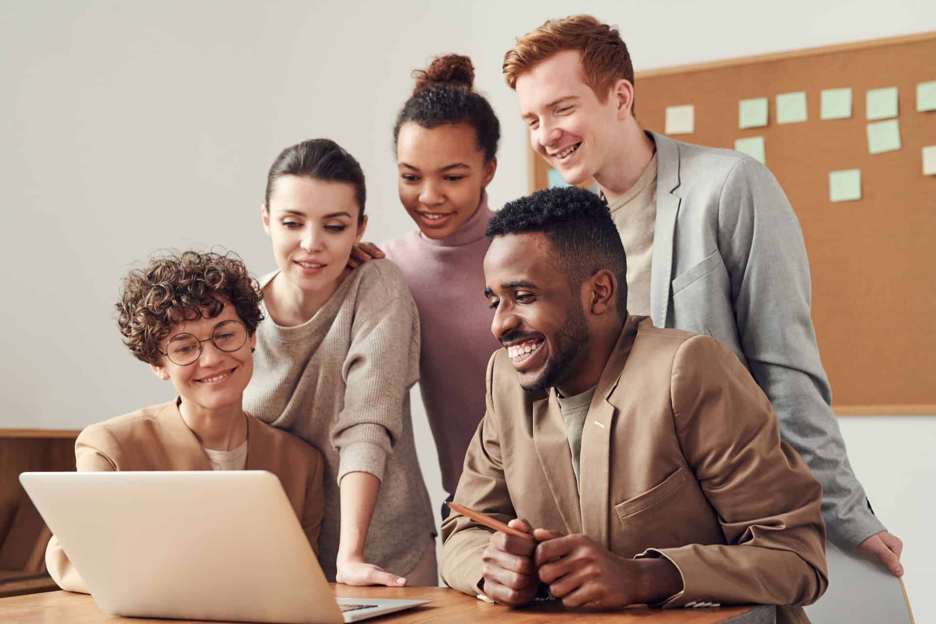 Happy team looking at laptop