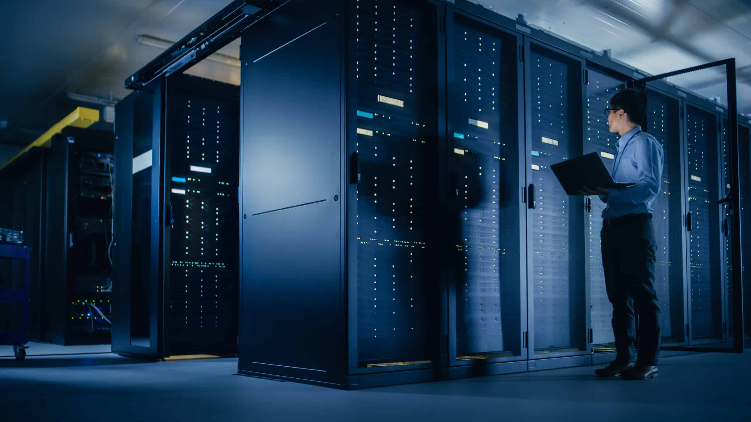 Man with laptop in server room