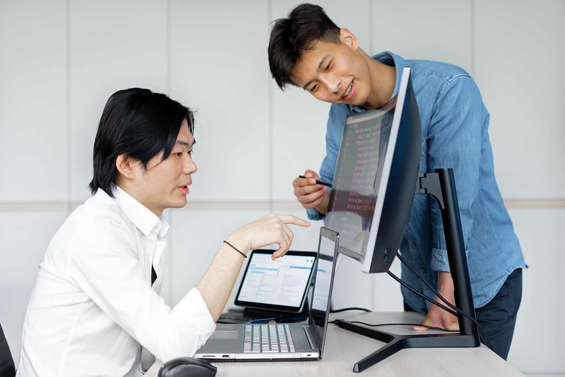 Two men pointing at PC screen