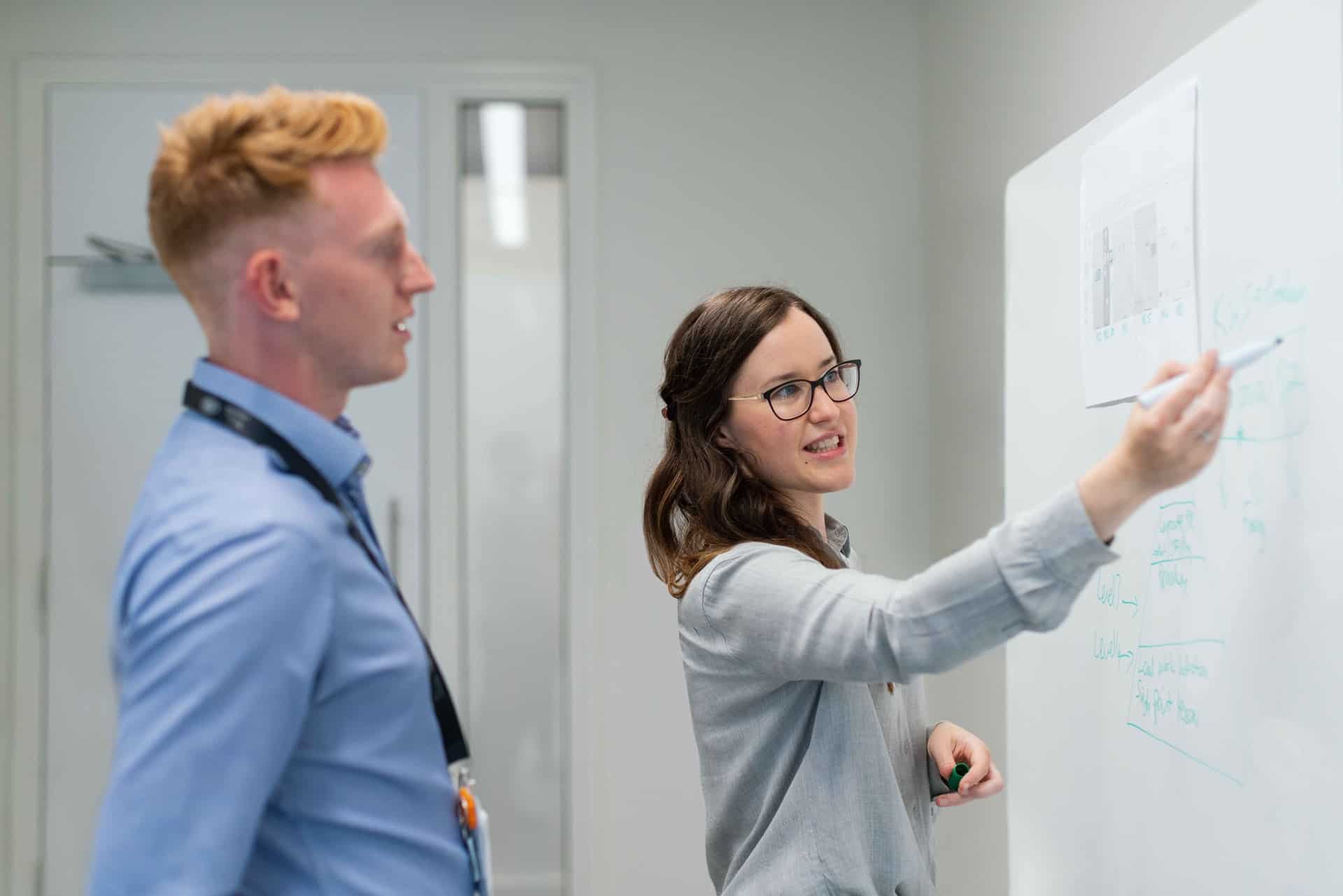 Man and woman using whiteboard