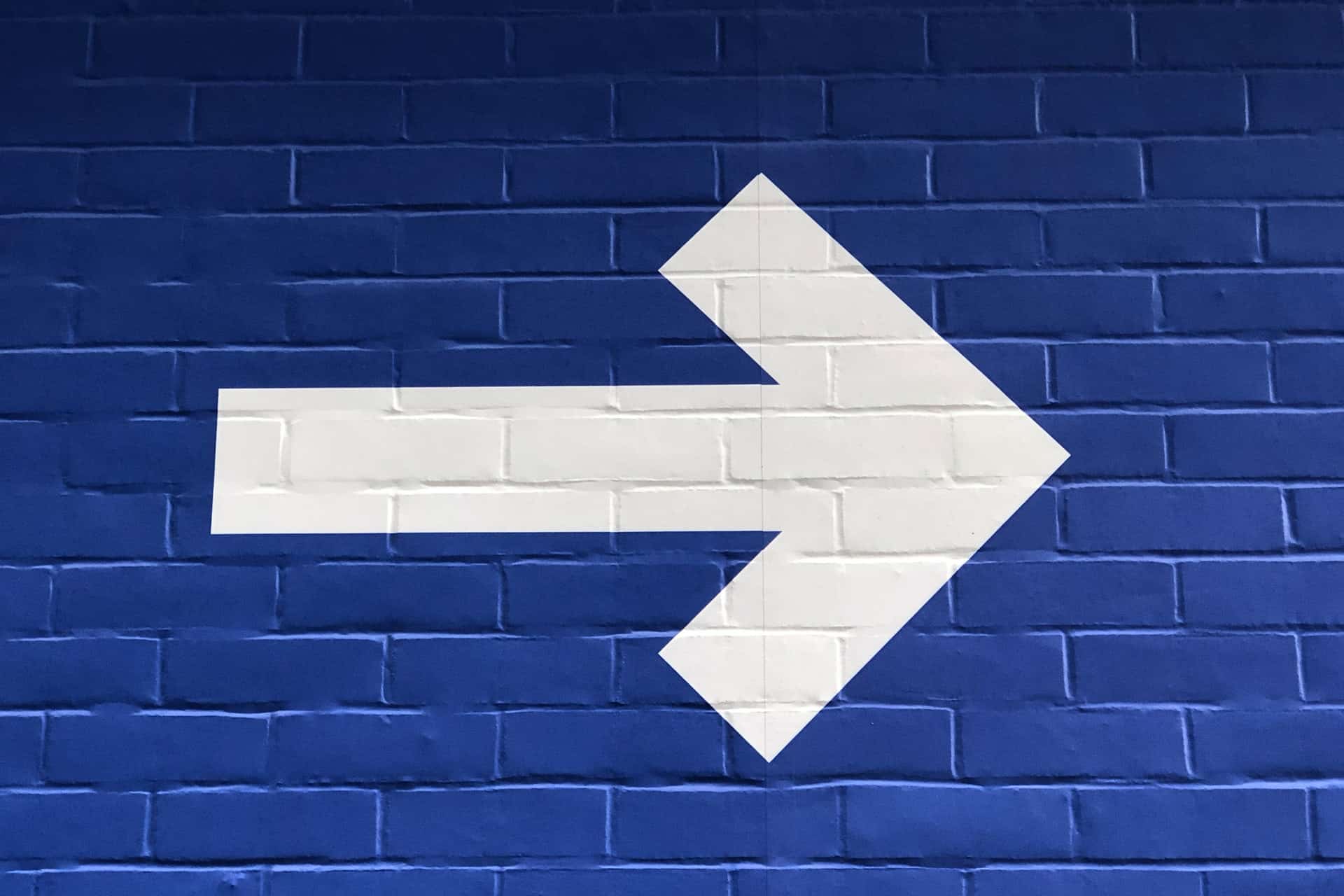 White arrow on blue wall