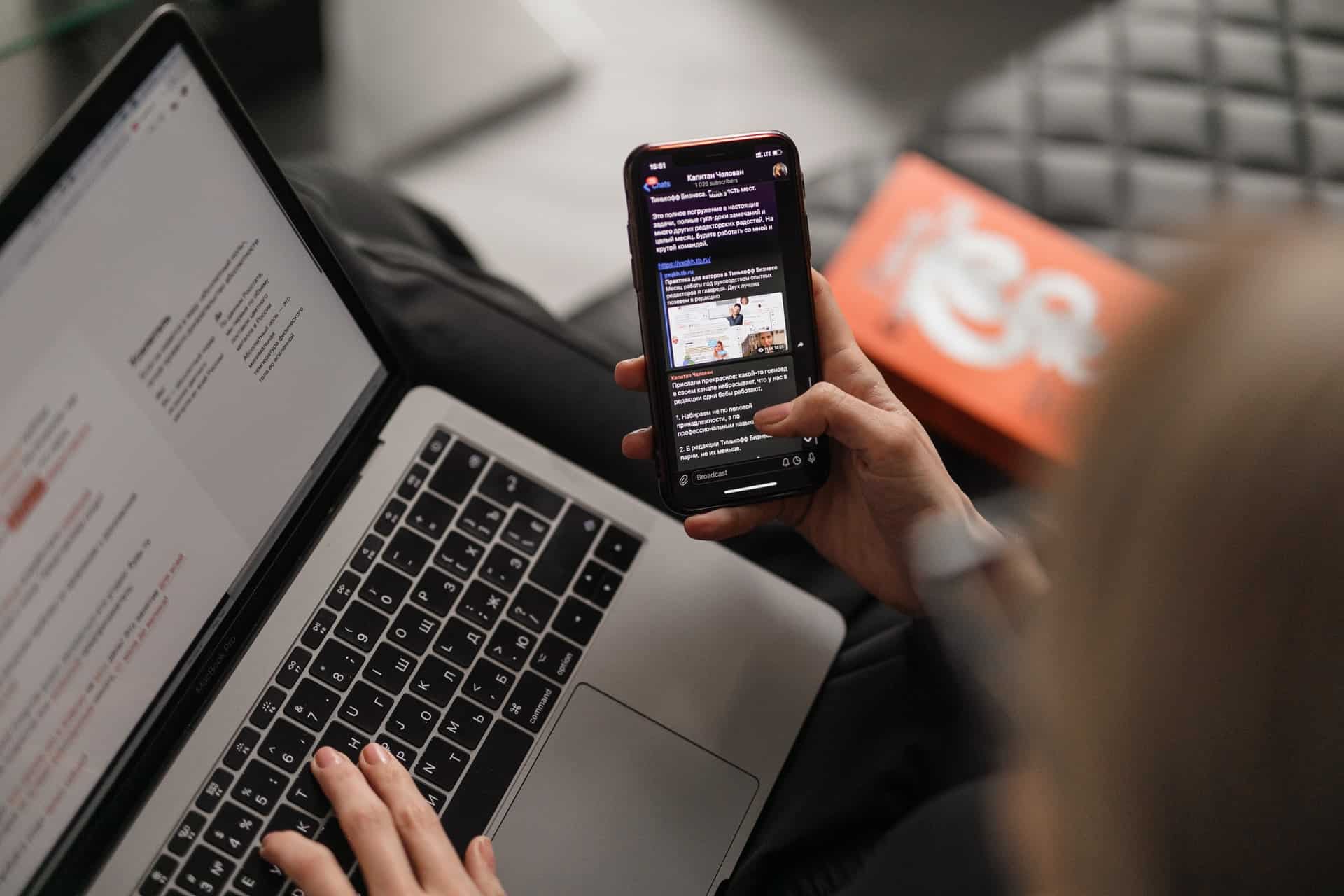 Woman using phone and laptop