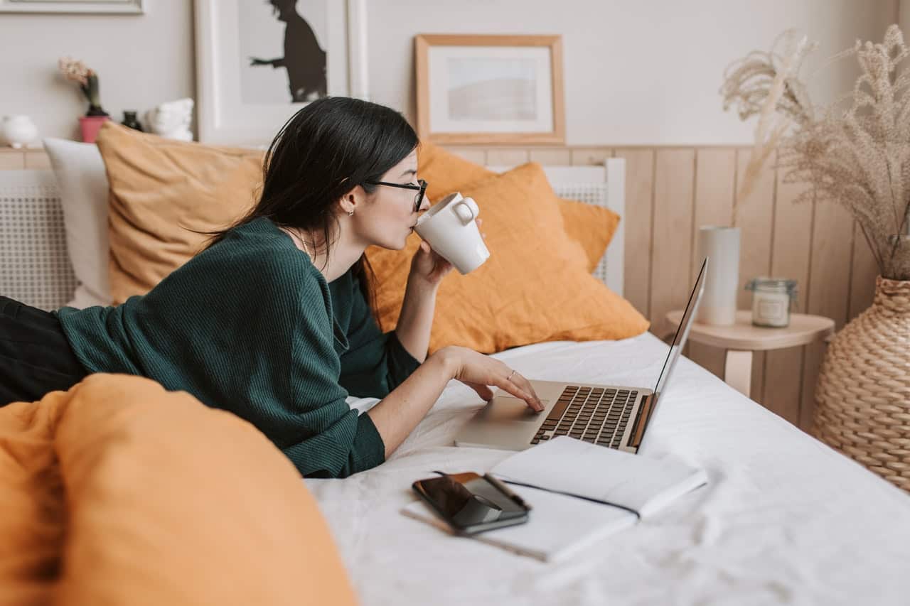 Woman using laptop in bed