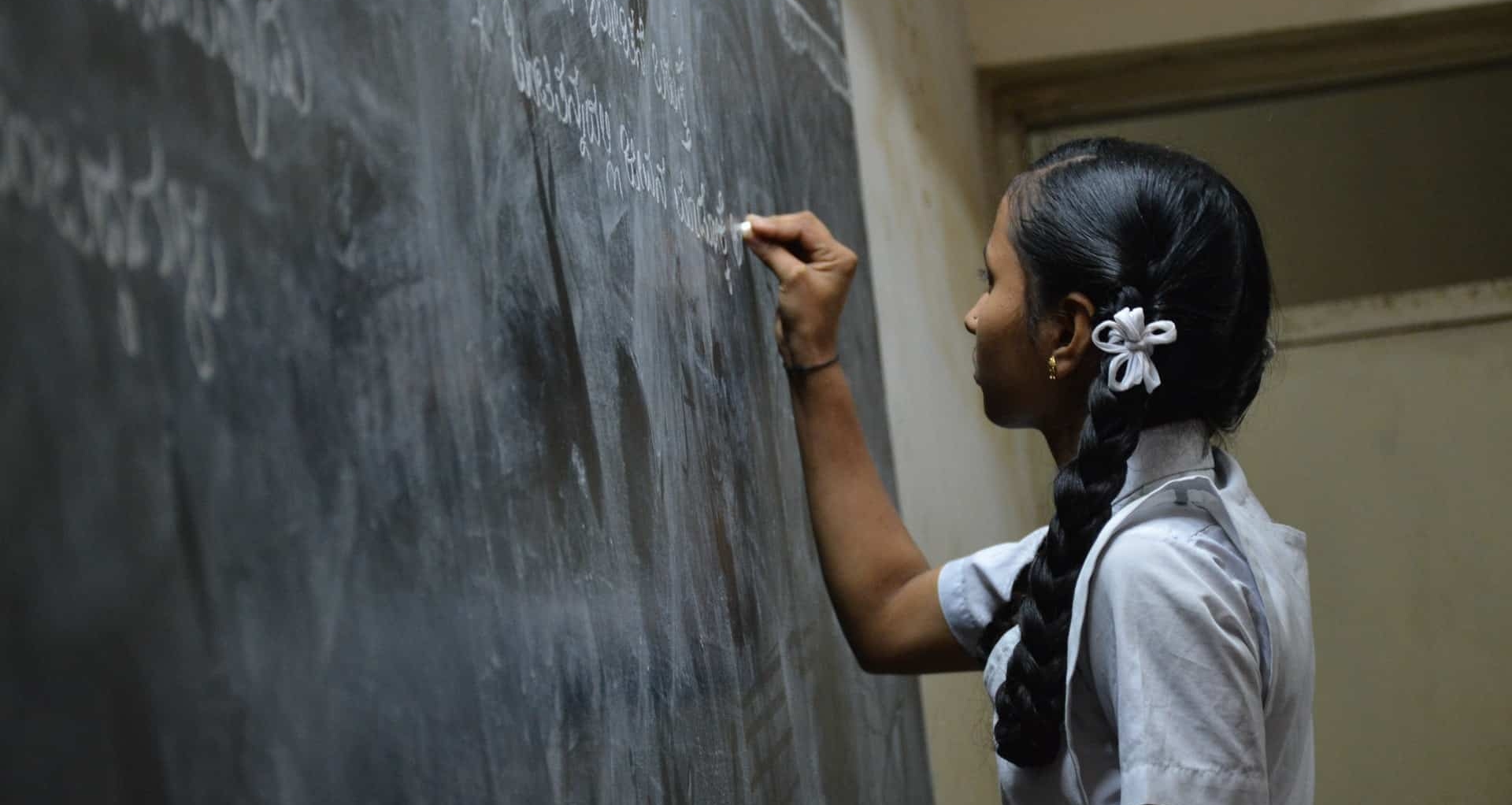 Girl writing on board