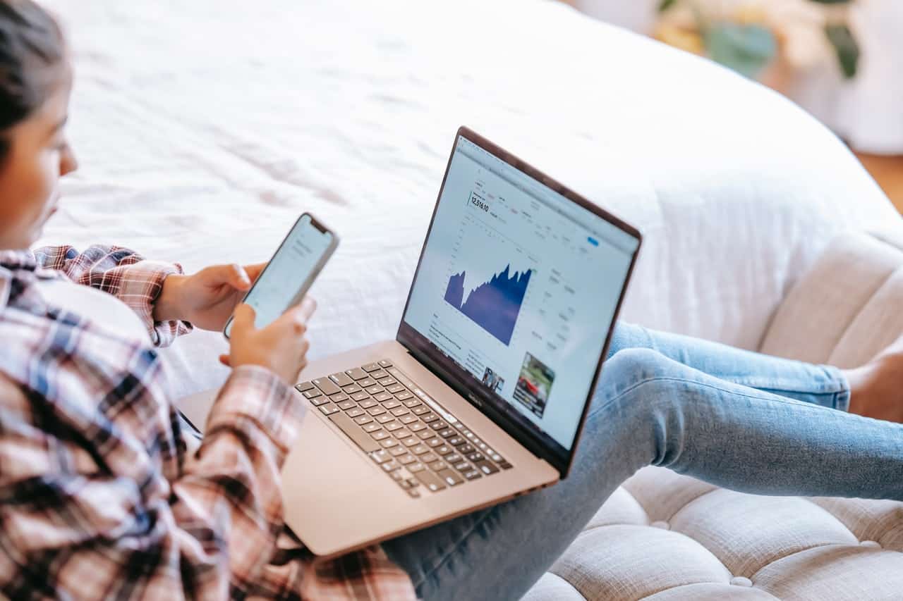 Woman using mobile phone and laptop