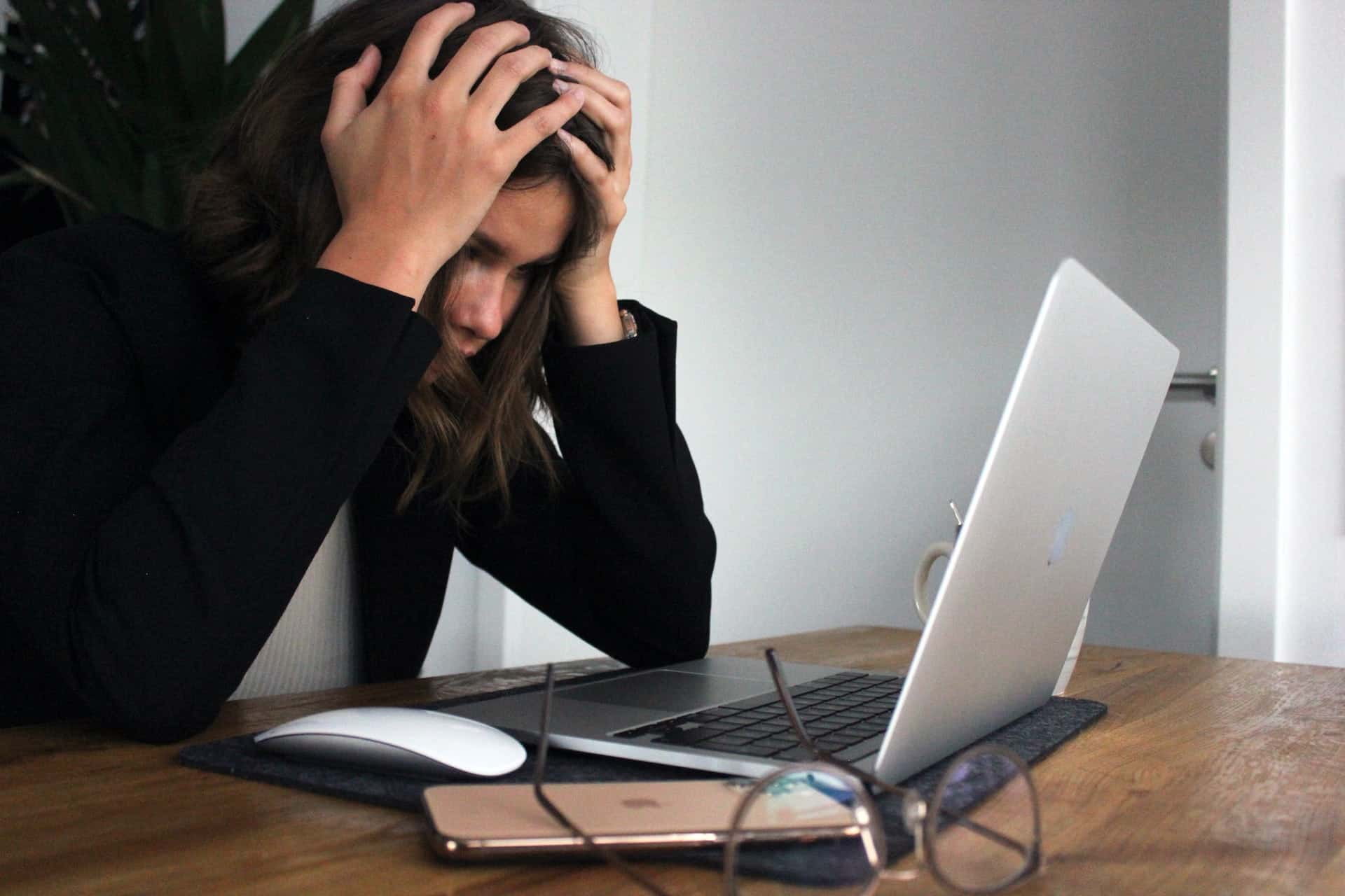 Worried woman looks at laptop