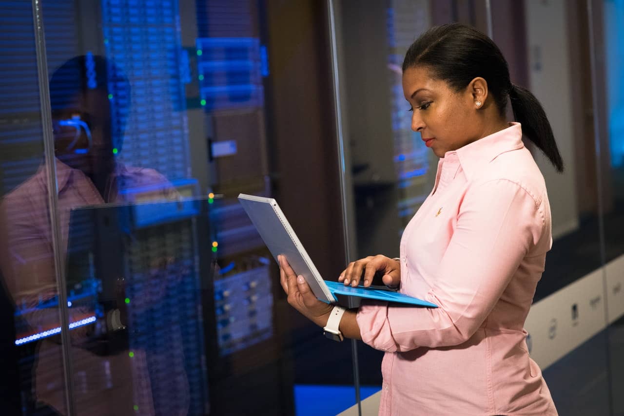 Woman using laptop in server room