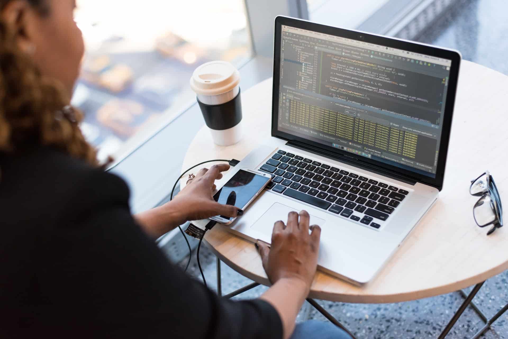 Woman using laptop and mobile phone